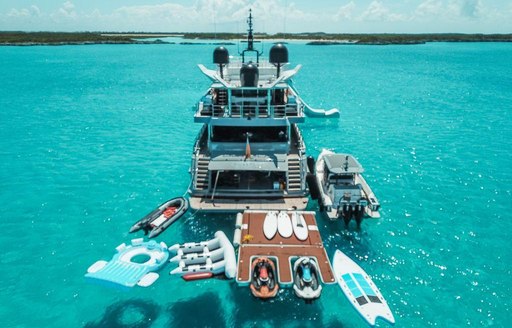 View of back of superyacht OCULUS with tenders around it