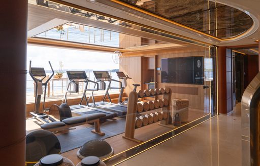Gym onboard charter yacht KISMET with equipment facing large window