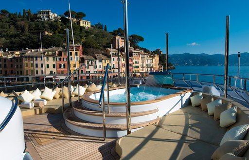 An image which shows the Jacuzzi on a superyacht with Portofino in the background