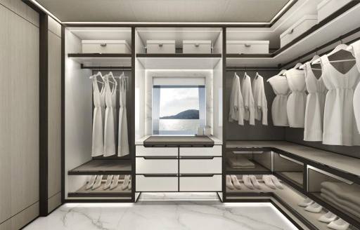 Walk-in wardrobe with white clothing hanging in the master cabin onboard yacht charter AKULA