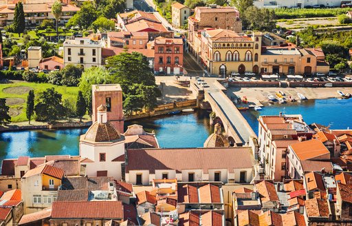 Waterways in Sardinia, with beige houses and green trees. mediterranean yacht charter destination