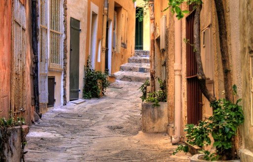 narrow cobbled alley of houses rising up to steps