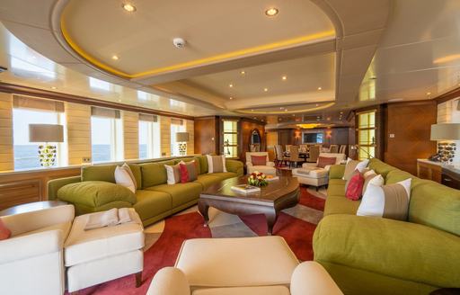 Main salon onboard charter yacht KAISER, with green seating and many windows