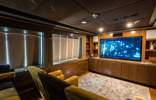 Cineam room on luxury charter yacht ARESTEAS with comfy chairs lined up infront of wide screen TV