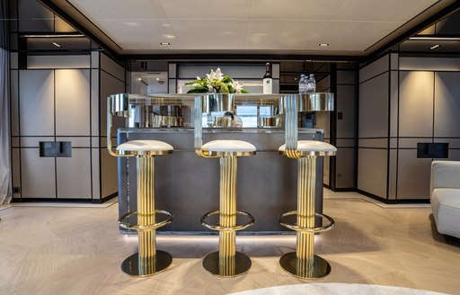 Wet bar onboard charter yacht RELIANCE with three stools in foreground