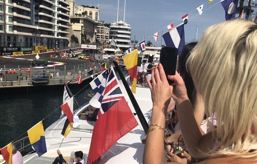 cars on circuit during monaco grand prix as seen from a luxury yacht