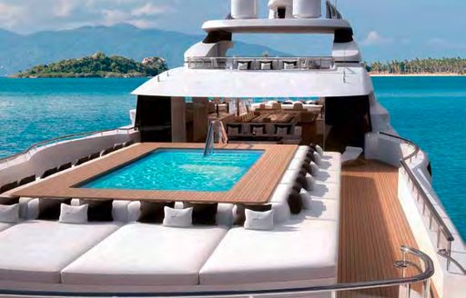 huge pool surrounded by plush sunpads on big charter yacht LANA