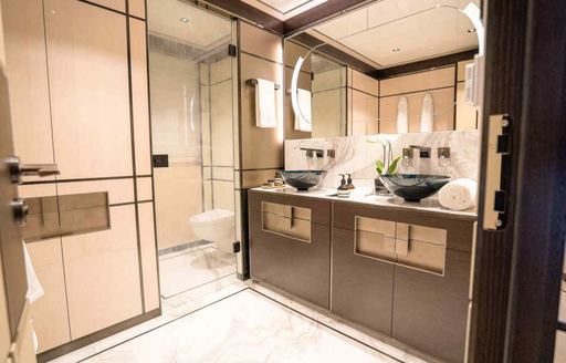 A guest cabin ensuite onboard charter yacht RELIANCE with dual sinks