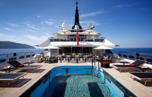 Overview of the swimming pool and adjacent sunloungers onboard superyacht charter ALFA NERO