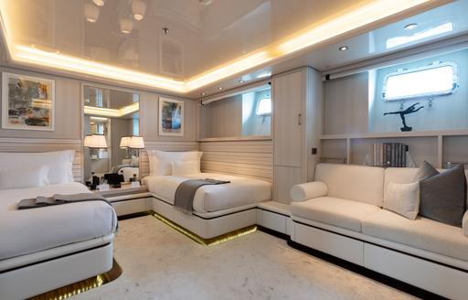 Twin cabin with two single berths and a white sofa onboard charter yacht ETERNITY