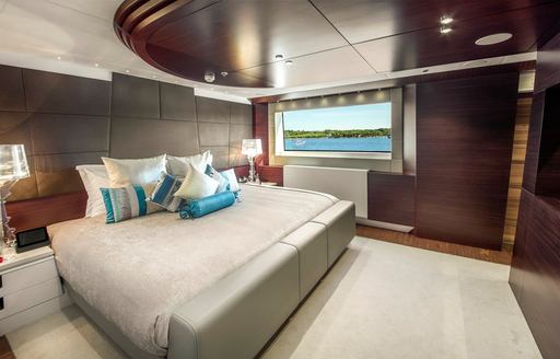 Guest cabin with central berth and large window onboard charter yacht KATINA