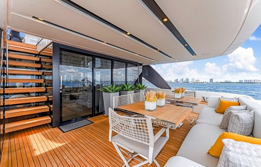Table and directors chairs on exteriors of superyacht charter NOTYNOG