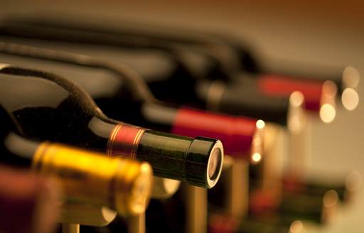 Red wine bottles lined up in a rack