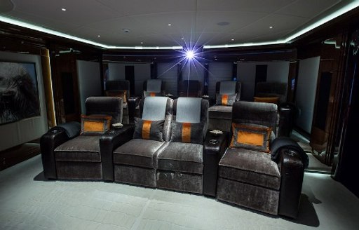 Darkened cinema on superyacht Arience showing plush seating