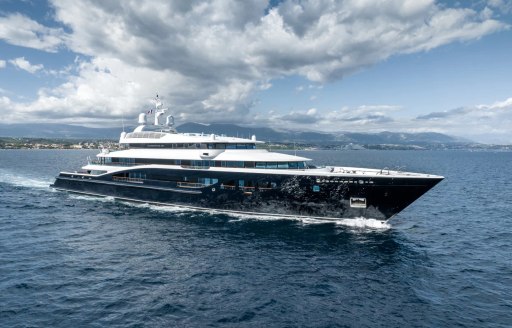 Charter yacht CARINTHIA VII underway, surrounded by sea with land in the far distant background