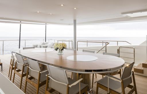 Exterior dining table and surrounding chairs onboard charter yacht ANDIAMO