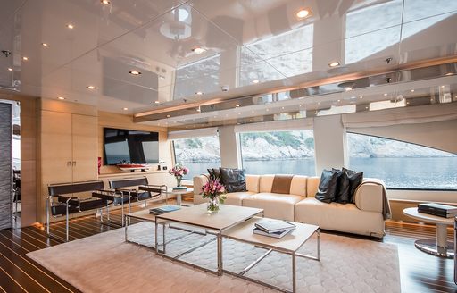 Comfortable interior of superyacht ARBEMA, with cream sofas, large windows and flatscreen TV on wall