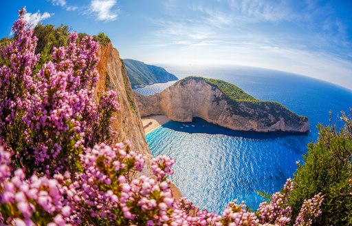 Bay in Greece with pink flowers in foreground, the ideal superyacht chartr vacation