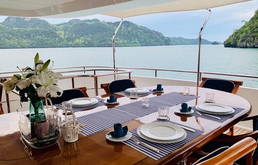 Alfresco dining area onboard charter yacht LADY AZUL with long table set for a meal