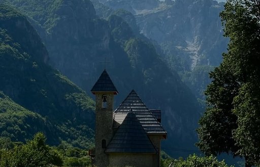 Building with backdrop of Albanian Alps