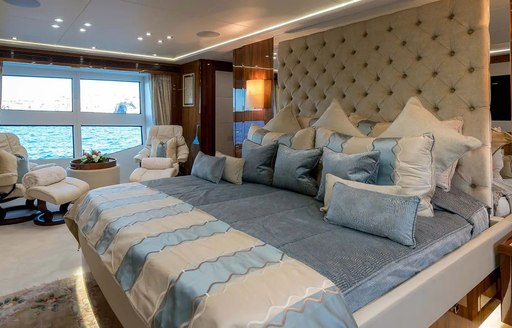 Owner's cabin on board superyacht ANYA, with bright windows and blue bedding