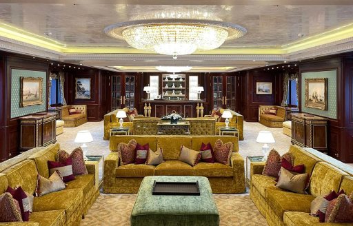 Overview of the main salon lounge area onboard charter yacht BLACK PEARL with plush golden sofas 