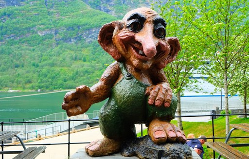 large statue of troll in norway by the water