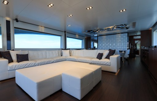 White L-shaped sofa in main salon of charter yacht Paradise 