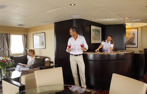 charter guests enjoy cocktails in sky lounge of luxury yacht L’Albatros