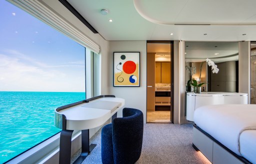 Master cabin with bureau facing out of a large window onboard charter yacht CARPE DIEM