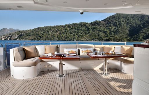 Exterior seating area with large sofa onboard charter yacht QUEST R