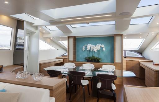 Interior dining setup onboard charter yacht 55 FIFTYFIVE with a long table surrounded by windows