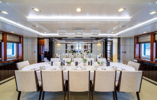 Interior dining area with long table and surrounding chairs onboard charter yacht HOLDIN' MY OWN