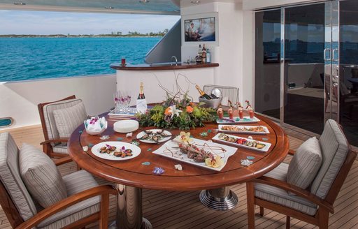 circular table set for dinner on aft deck of luxury yacht AMITIÉ 