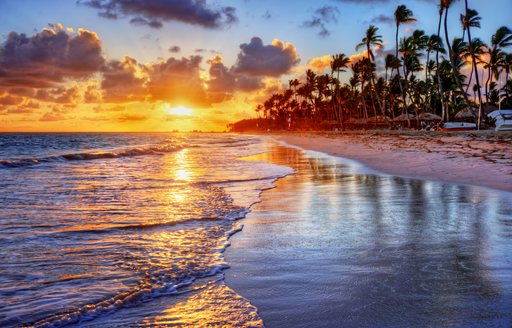 A deserted sandy beach with a sunset