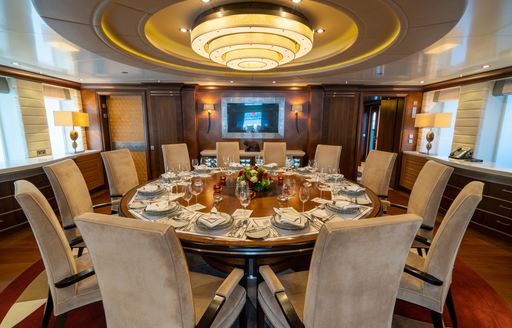 Interior dining room with circular table onboard charter yacht KAISER