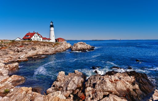 Lighthouse perched on rock by sea in New England