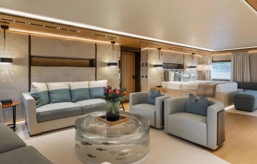 Private seating area with sofa and armchairs in the master cabin onboard charter yacht LA DATCHA