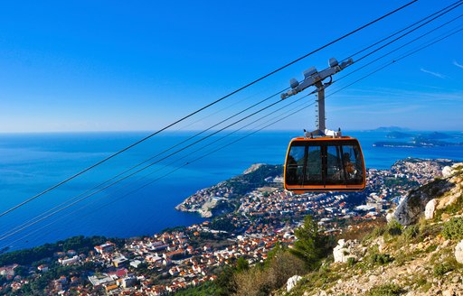 A cable car in transit looking down over the Croatian coastline