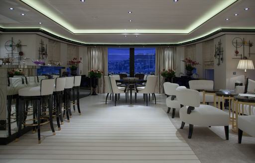 Interiors with wet bar and white seats onboard charter yacht PLAN B