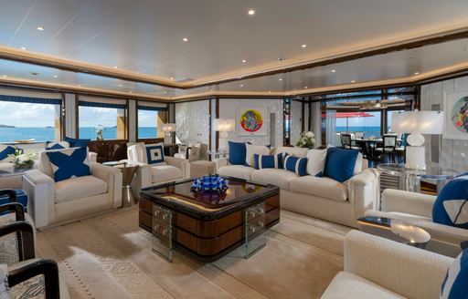 Interior lounge with white sofas and blue cushions onboard charter yacht ALFA NERO