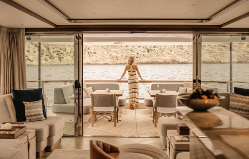 woman stands on yacht enjoying the sights