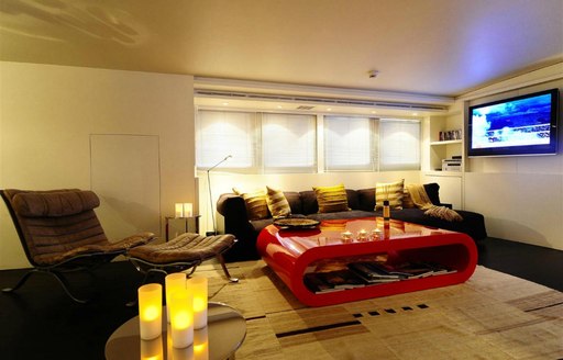 main salon lounge with brown sofa and red coffee table on board luxury yacht BERZINC 