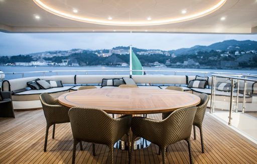 circular dining table on upper deck aft of motor yacht OKKO 