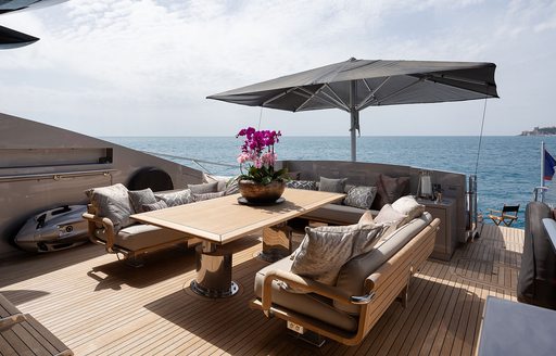 Alfresco dining table, seats and parasol onboard charter yacht BAGHEERA