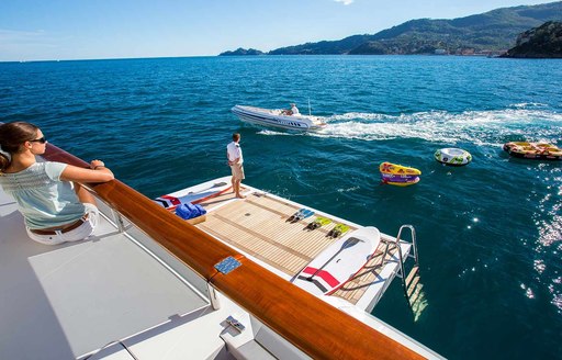 Woman looks over swim platform on luxury yacht DIANE