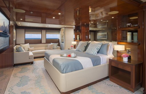 rich wooden wall panels and large bed facing a TV in the master suite aboard luxury yacht Time For Us 