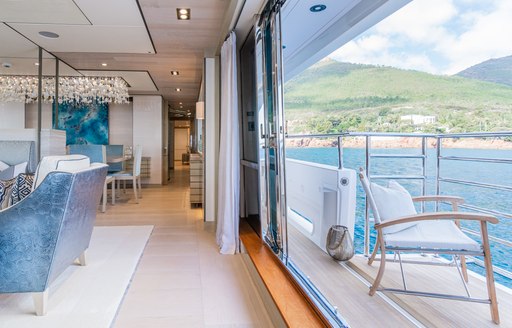 Fold down balcony onboard charter yacht THUMPER, with a white chair overlooking the sea