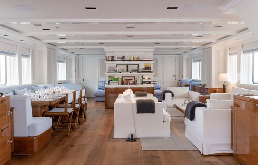 Open plan interior with sofas and dining table on explorer yacht 'Blue II'