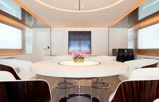 Interior dining table with white seating onboard charter yacht ASLEC 4